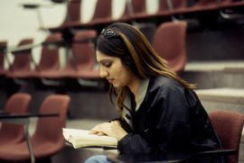 Photograph of a student sitting in the Lecture Theatre and studying