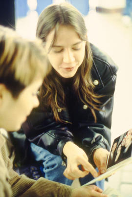 Photograph of two students looking at photos in an unknown location