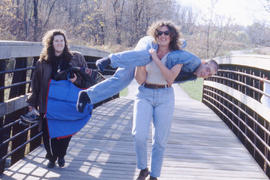 A photograph of three students on a bridge in the Arboretum
