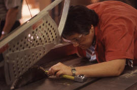 Photograph a student working with the blade on a table saw