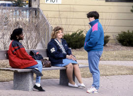Photograph of students sitting outside on a bench