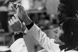 Photograph of a Chemistry Student Holding Up and Analyzing a Tube