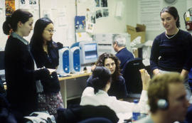 Photograph of students engaged in a discussion in journalism lab