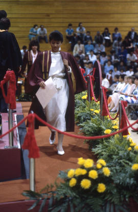 Photograph of a Graduate returning to seat after receiving Diploma