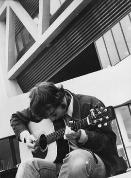 Photograph of a Student Playing the Guitar Outside
