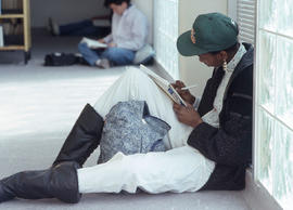 Photograph of a student completing work in the hallway