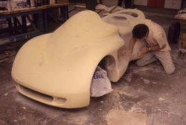 Photograph of student working on model car