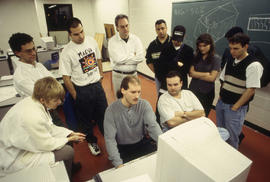 Photograph of students gathered around to learn (CAD)