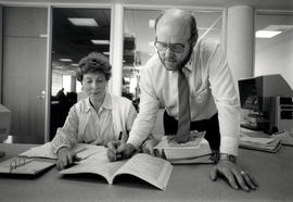 Photograph of Doug Willford assisting Margie Zekulin with research in the library