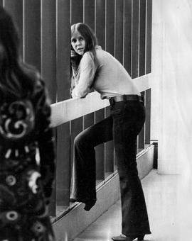 Photograph of a Student standing in the Hallway by the Windows