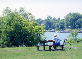 Photograph of a community visitor to the Arboretum sitting on a picnic bench