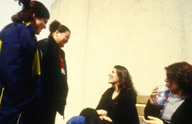 A photograph of four students chatting