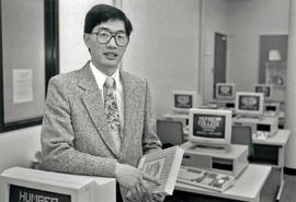 Photograph of Mike Koyanagi Standing in a Computer Lab in the Test Centre
