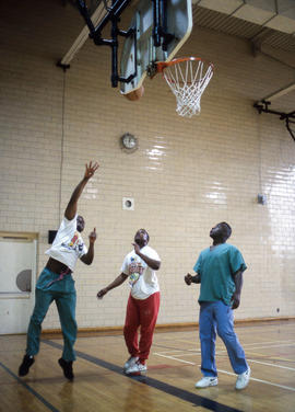 Photograph of three students playing a friendly game of basketball