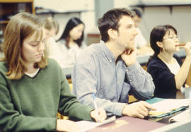Photograph of  students sitting in class and listening to a lecture