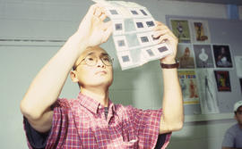 A photograph of an Industrial Design student looking at slides