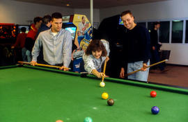 Photograph of students playing a game of snooker in the games room