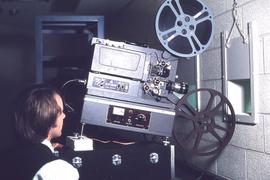 Staff projecting film in to lecture theatre : [photograph]