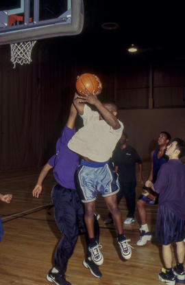Photograph of a group of students playing a pick-up game of basketball in the gymnasium of the Go...