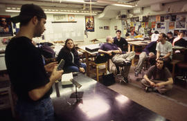 A photograph of an Industrial Design student presenting to his class
