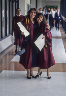Photograph of Two Graduates Hugging in the Hallway