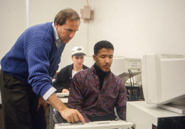 Photograph of George Byrnes assisting a student in his class