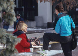 Photograph of students sitting outside in one of the courtyards in winter.