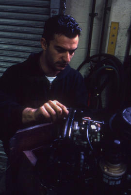 Photograph of a student working on a small engine