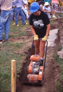 Photograph of a student in the Landscape program flattening soil