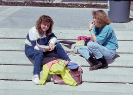 Photograph of two students sitting on stone steps