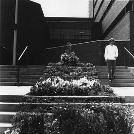 Photograph of a Student Walking Down the Stairs Exiting the Osler Building