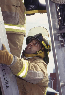 A photograph of Firefighting students climbing a ladder