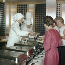 Photograph of staff serving a few guests