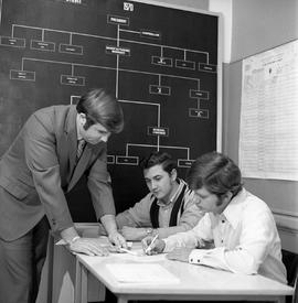 Photograph of Bill Pitt explaining organization structure to students