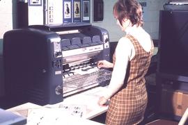 IMC staff member at copying machine : [photograph]