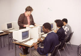 Photograph of instructor and their students in a computer lab