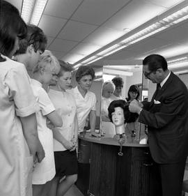 Photograph of Jacques Granville demonstrating  a "comb out" to Hairdressing apprentices