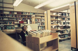 Photograph of Audrey MacLellan sitting in the Lakeshore 1 library reference desk
