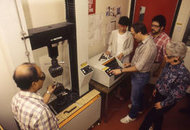 Photograph of an Instructor With Students Using Machines