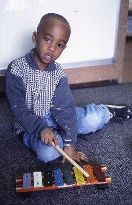Photograph of a young child sitting on the floor