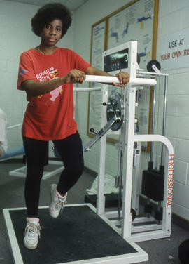 Photograph of a student standing next to fitness equipment
