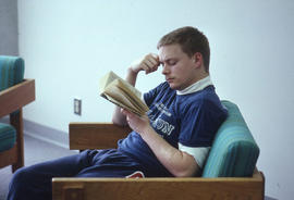 Photograph of a student reading in the library