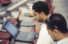 Photograph of student using a laptop computer in the lecture theatre.