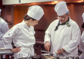 Photograph of Culinary Management faculty member Frank Formella demonstrating a cooking skill to ...
