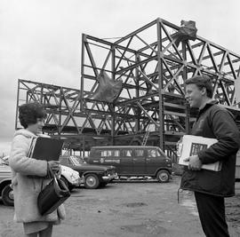 Photograph of two students in front of the construction of the J building