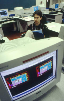 Photograph of student sitting in a computer classroom studying