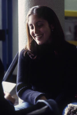 A photograph of a student leaning against a column