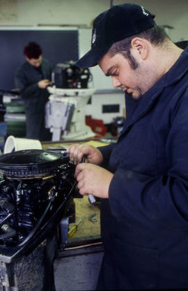 Photograph of a student working on a small engine