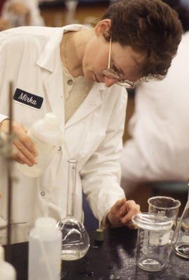 Photograph of a Pharmacy Assistant Pouring Liquid Into A Class Container