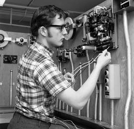 Photograph of a student connecting components on an electrical test bench